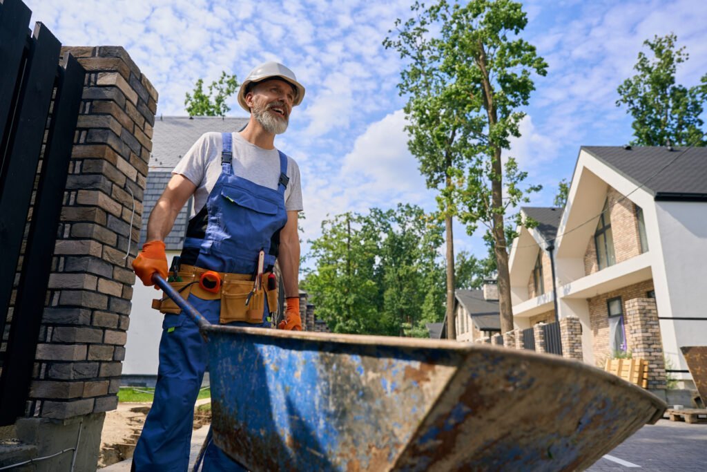 Yard worker transferring building materials on site in morning